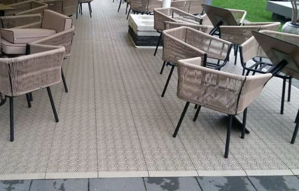 Bašta kafića sa stolovima i stolicama na svetlo-tamnoj šahovskoj podlozi