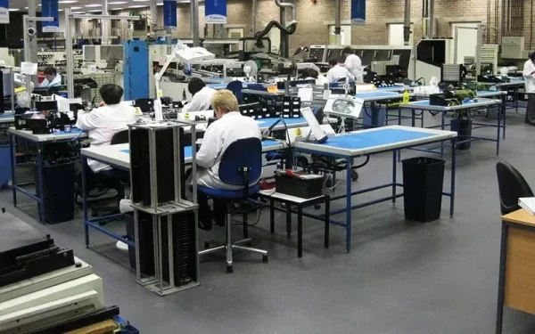 Radnici u proizvodnji elektronike za montažnim stolovima na ESD podu
