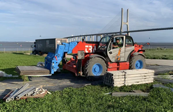 Viljuškar prelazi preko zaštitnih ploča noseći građevinski materijal