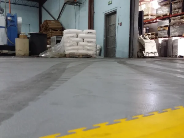 Industrijski pod u magacinu sa žutom ivičnom rampom