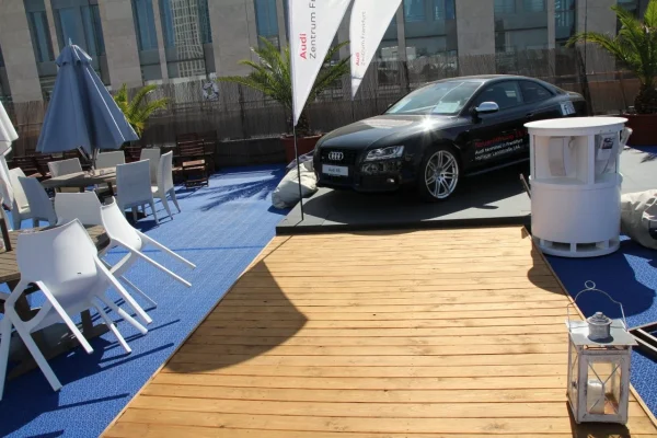 Automobil i sedeći deo na otvorenom izložbenom prostoru sa modularnom podlogom
