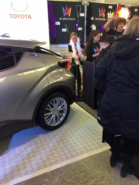 Automobil na promotivnom štandu sa modularnom podlogom i posetiocima