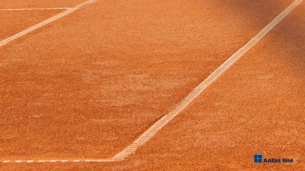 Detalj šljakaste površine teniskog terena sa belom linijom